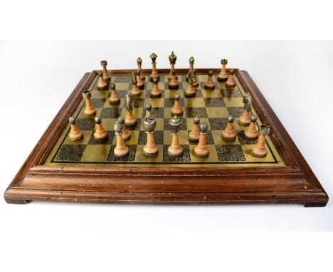 A brass chessboard mounted in a wooden frame and a set of turned and metal mounted chess pieces, height of king approx. 7.5cm