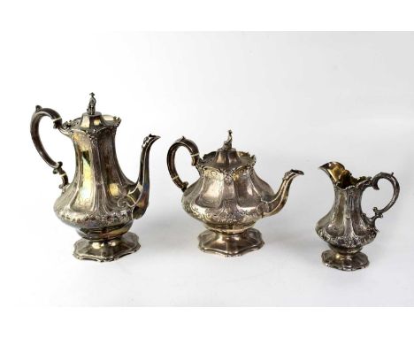 A Victorian silver part tea service of baluster form with repoussé decorated panels and scroll handle, comprising teapot, hot