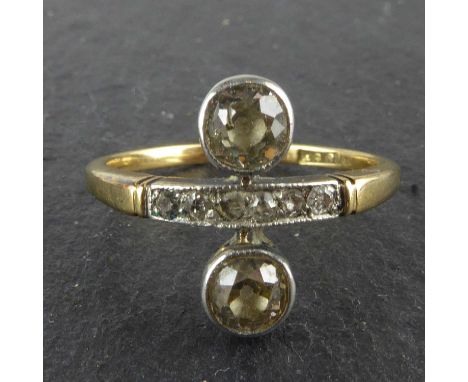 An Art Deco 18ct gold ring, with short pavé set band of six tiny diamond chips flanked by two bezel set brilliant cut diamond