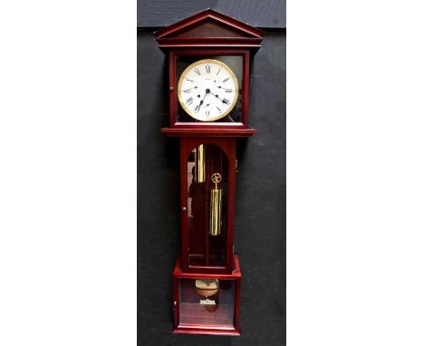 W. M. WIDDOP; a modern mahogany cased wall clock in the form of a longcase clock of small proportions, with glazed arched hoo