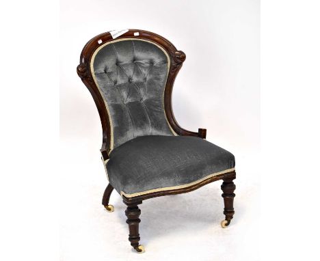 A Victorian carved walnut nursing chair, with button back upholstery, in blue velour and on turned legs with castors, height 