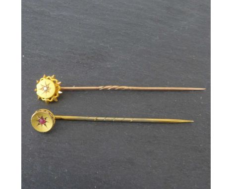 A 15ct gold pin with a circular star top and central diamond chip, approx. 1.4g, and a 9ct gold pin with circular top and cen