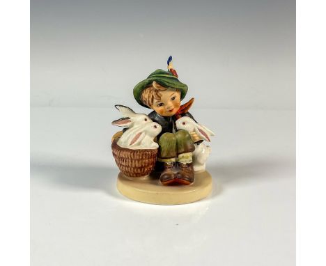 A matte and glossy figure of a smiling boy as his white rabbits gather around him. M.I. Hummel impressed. Goebel backstamp. A