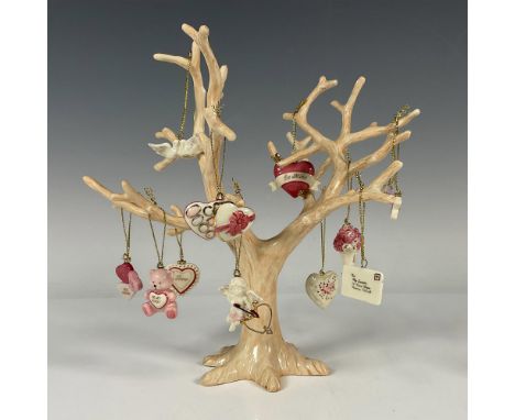 A figure tree that can be adorned with 12 Valentine's Day theme ornaments such as bouquet of roses, kissing doves, candy hear
