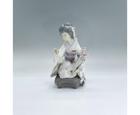 A glossy figure of a woman wearing a floral kimono, kneeling as she carefully picks flowers to add to her bouquet. Lladro bac