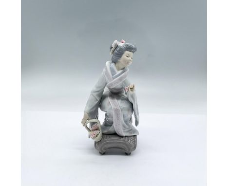 A glossy figure of a woman dressed in a floral-patterned kimono, crouching down with a basket and holding a flower. Lladro ba