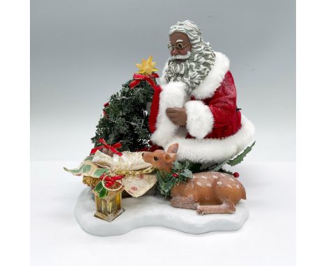 Resen and cloth figure of an African American Santa Claus admiring the sleeping baby. Glittery snow. The tree and lantern has