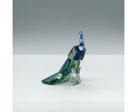 A dazzling faceted blue and emerald crystal figure of a bird with a smooth iridescent head, black eyes, and metal feet, perch