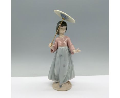 A young girl in a red shirt and teal skirt gracefully holds a parasol over her head. Lladro backstamp. This item has its orig