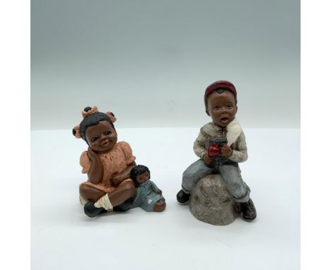 Two figurines depicting African American children with Martha Holcombe hallmarks. The figurine with the name Rachel measures 