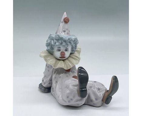 Tired clown reclining and dressed in pastel lavender jumper. Glossy finish. Lladro backstamp. This item has its original box.