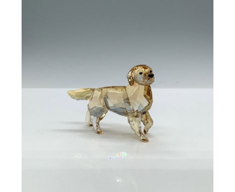 A clear faceted figure of a golden-hued mother dog standing with one paw delicately lifted, featuring black eyes and nose. Ar