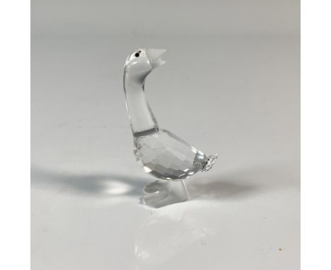 A goose that is looking is looking behind. It has a clear cut crystal body, frosted bill and feet and black eyes. This item h