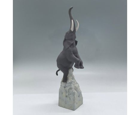 Matte porcelain combined with enamels in the base of the piece. Grey elephant rearing on his hind legs lifting his trunk and 