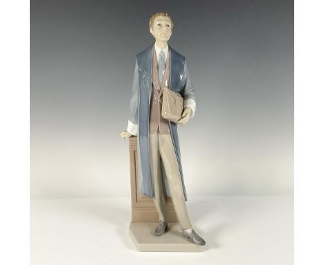 A tall glossy sculpture of a lawyer wearing a long blue coat and holding a brown briefcase. Lladro backstamp. Artist: Salvado