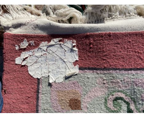 A large bordered, patterned and fringed Carpet in pink and green geometric pattern (some slight marks and spark burns), 10' x