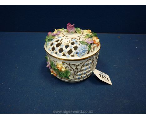 An exquisite Dresden lidded pot with pastel coloured encrusted flowers and lattice work panels highlighted with Forget me Not