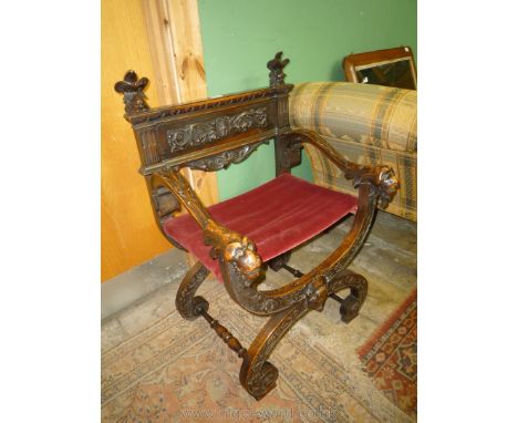 An elegant Mahogany 'X' framed open armed Armchair having carved and blind fretworked decoration, the arms terminating in fer