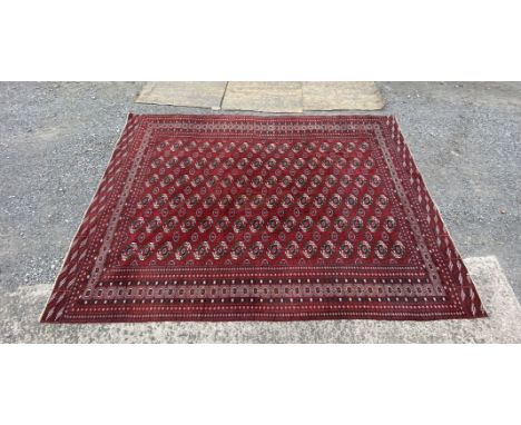 A large red and black bordered, patterned and fringed Carpet, 13'6 x 9'3 1/2" (4.1 m x 2.8 m approx)