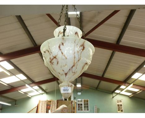 A hanging glass lamp shade in brown and white mottled tones with embossed rope decoration.