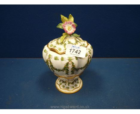 A hand-painted Vase with flower finial lid, decorated with leaves and roses and bugs with mark to base (xBs?), 7" tall, 4" wi