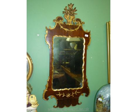 An ornately framed Mahogany wall Mirror with gilt painted borders, floral carving and finial, 44" high x 20 1/2" wide.
