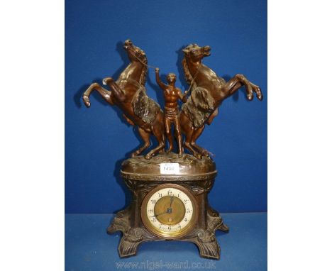 An imposing spelter framed Clock surmounted by an athletic young gentleman wearing a loin cloth, restraining a pair of rearin