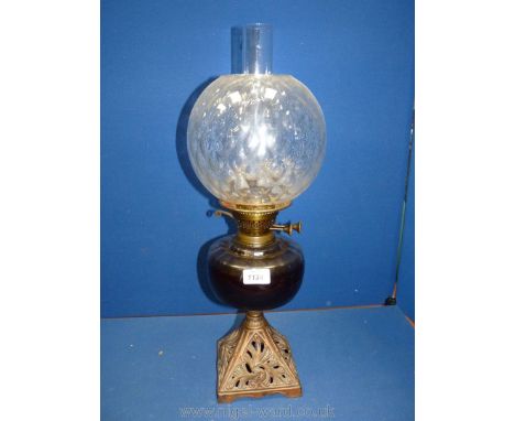 A Victorian Oil Lamp having duplex twin burner, central glass bowl and glass shade with diamond pattern, set on bronzed trian