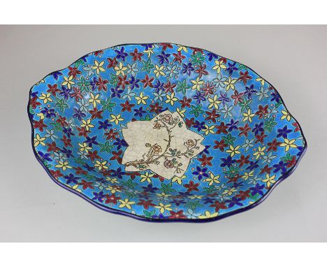 A French Longwy pottery shaped oval dish with floral decoration on blue ground and painted central panel of blossom on crazed