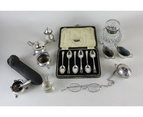 A cased set of six silver plated teaspoons, a glass inkwell, a silver plated cruet set, a cased pair of Victorian spectacles,