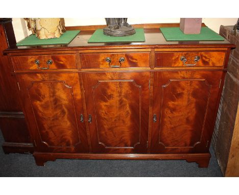 A 20th century mahogany sideboard with three drawers above cupboard enclosed by three panel doors, on shaped bracket base, 12