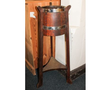 An R A Lister & Co Ltd, Dursley, England, barrel jardiniere on stand, the metal bound oak barrel on three legs with triangula