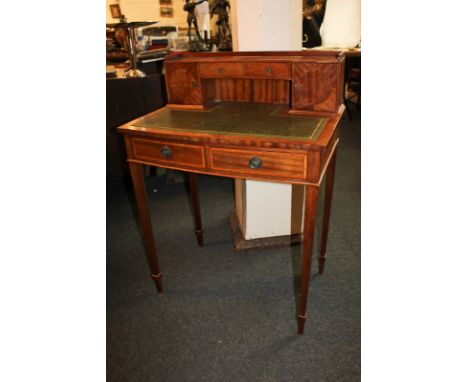 An inlaid mahogany writing table with raised shelf back with two small drawers and cupboards, green leather top over two draw