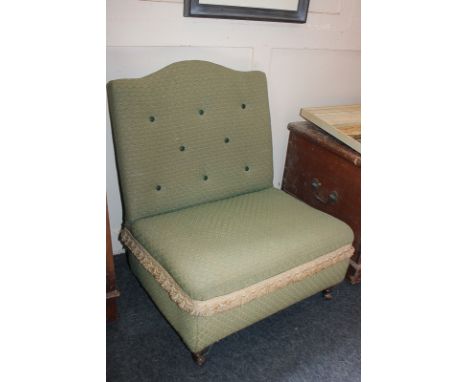 A green upholstered button back nursing chair, on castors
