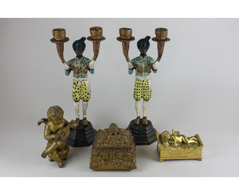A pair of painted metal two branch candelabra modelled as Moorish men, together with a seated cherub playing a lyre, a gilt b