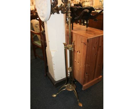 After Benson, an Art Nouveau brass standard lamp on tripod base with leaf shaped feet