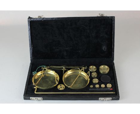A cased set of brass apothecary scales with weights