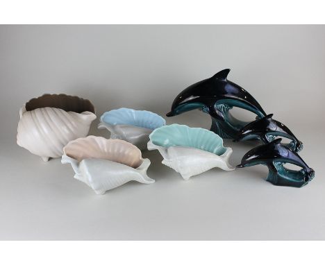 Four Poole Pottery seashells in twin-tone colourway, together with three Poole Pottery dolphin ornaments