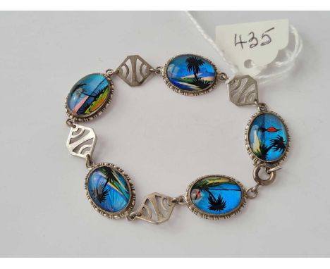 A vintage sterling silver and butterfly wing panel bracelet depicting tropical scenes 