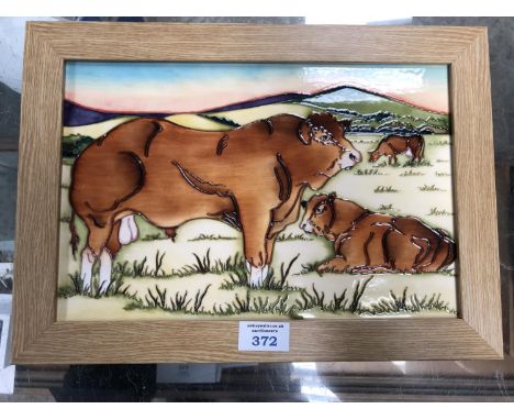 A MOORCROFT POTTERY 'LIMOUSIN BULLS' PATTERN LIGHT OAK FRAMED PLAQUE, 26 X 37CM 