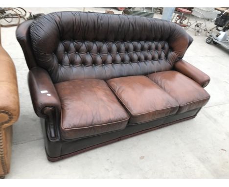 A BROWN LEATHER BUTTON BACK THREE SEATER SOFA 