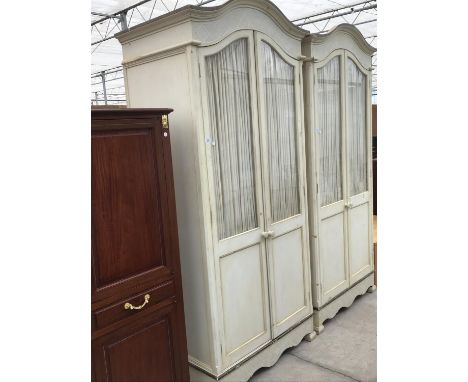 A CREAM PAINTED WARDROBE WITH TWO GLAZED DOORS HAVING INNER BUNCHED CURTAINS 