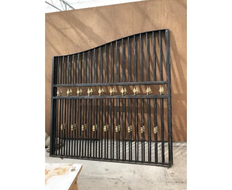 A LARGE PAIR OF BLACK METAL GATES WITH GOLD DECORATION  EACH GATE 205CM WIDE BY 210CM HIGH IN THE MIDDLE AND 180CM AT THE EDG