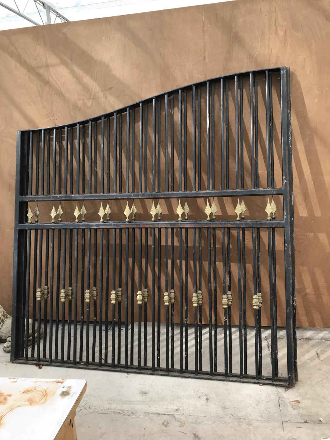 A LARGE PAIR OF BLACK METAL GATES WITH GOLD DECORATION EACH GATE 205CM