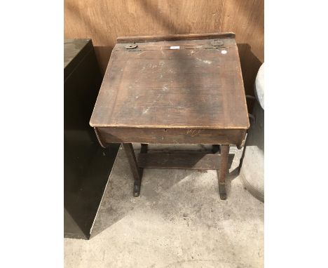 A VINTAGE WOODEN SCHOOL DESK WITH TWO METAL COVERED INK WELLS 
