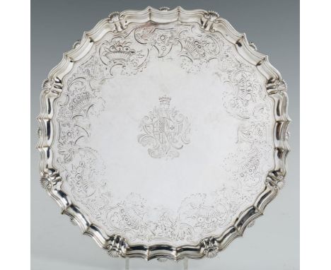 A GEORGE II SILVER SALVER  engraved with armorials and baskets of fruit, on four volute feet, 45cm diam, by John Tuite, Londo