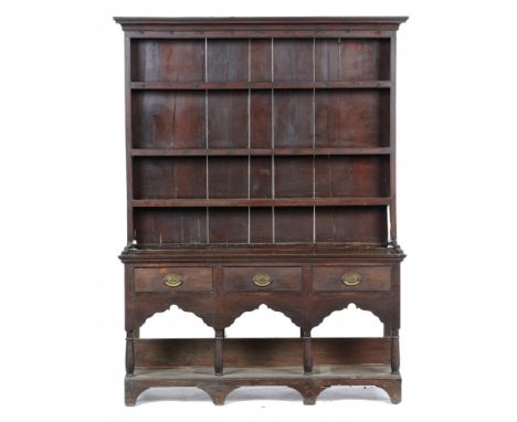 A GEORGE III OAK DRESSER  with cavetto cornice to the boarded three shelf rack, the base fitted three drawers, on turned legs