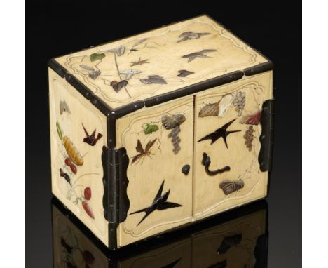 A JAPANESE MINIATURE SILVER MOUNTED SHIBAYAMA CABINET, MEIJI PERIOD fitted with three drawers enclosed by two doors, decorate