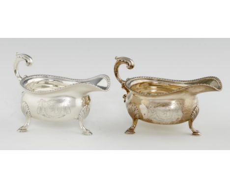 A PAIR OF GEORGE III SILVER SAUCE BOATS  with  gadrooned rim and leaf capped flying handle, on hoof feet,  engraved with armo