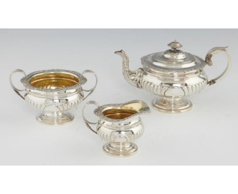 A SCOTTISH GEORGE III SILVER TEA SERVICE spirally reeded with foliate chased rim, teapot 17cm h, by W &amp; P Cunningham, Edi